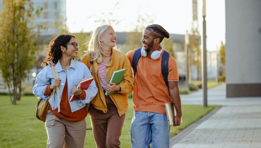 3 college students walking and laughing