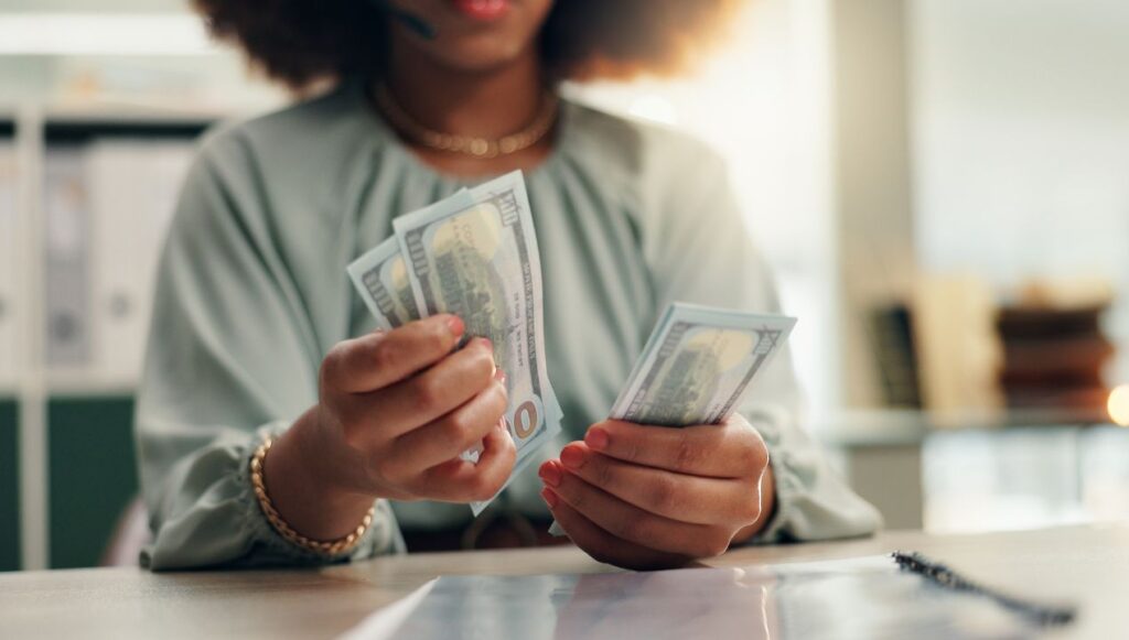 Woman counting money at table