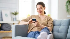 Woman browsing phone while on the couch