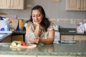 mom-looking-at-phone-while-cooking