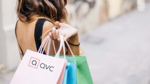 Woman carrying shopping bags with QVC logo