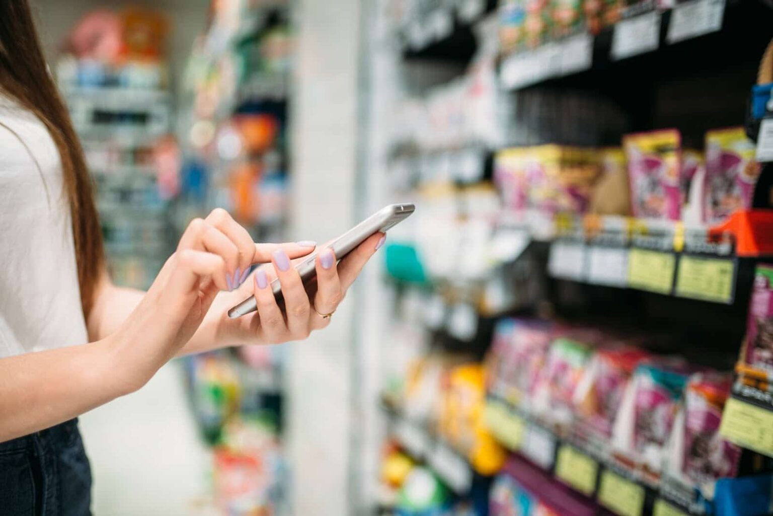 Woman interacting on mobile phone while shopping in store.