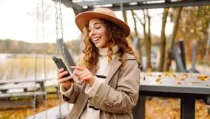 Woman sitting outside in fall on phone