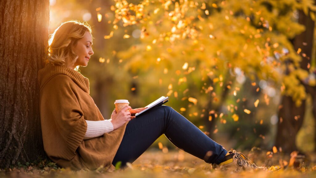 woman reading a book during fall season