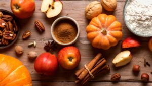Table with fall food ingredients like pumpkins and apples